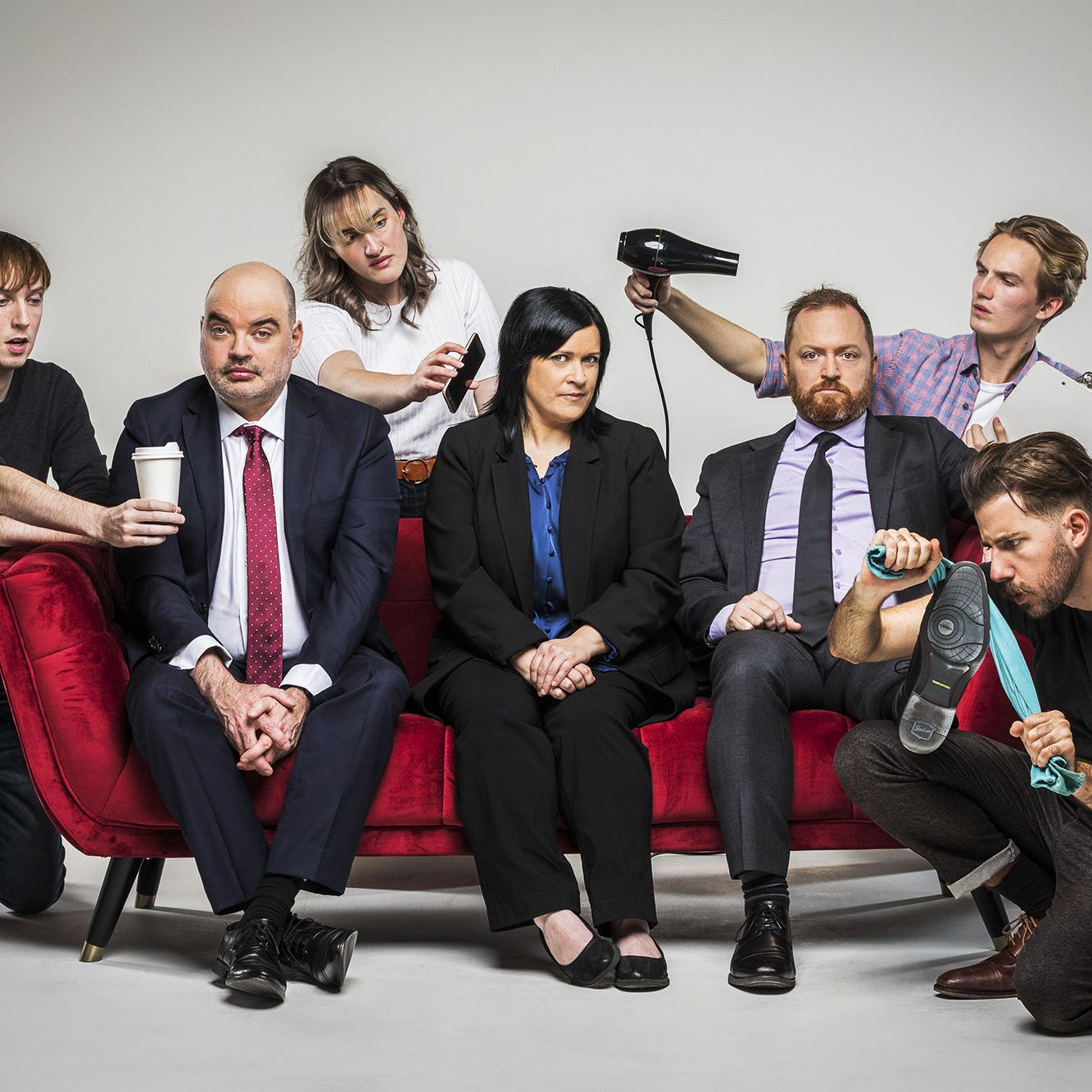 Editorial promotional studio photography of The Chaser 7 people seated on red couch